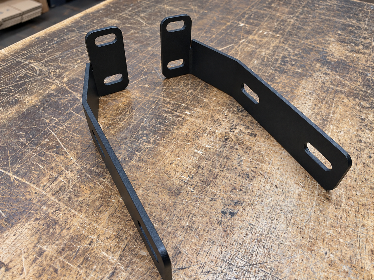 Close view of black powder-coated Datsun 280ZX tucked front bumper brackets and adjustment slots.