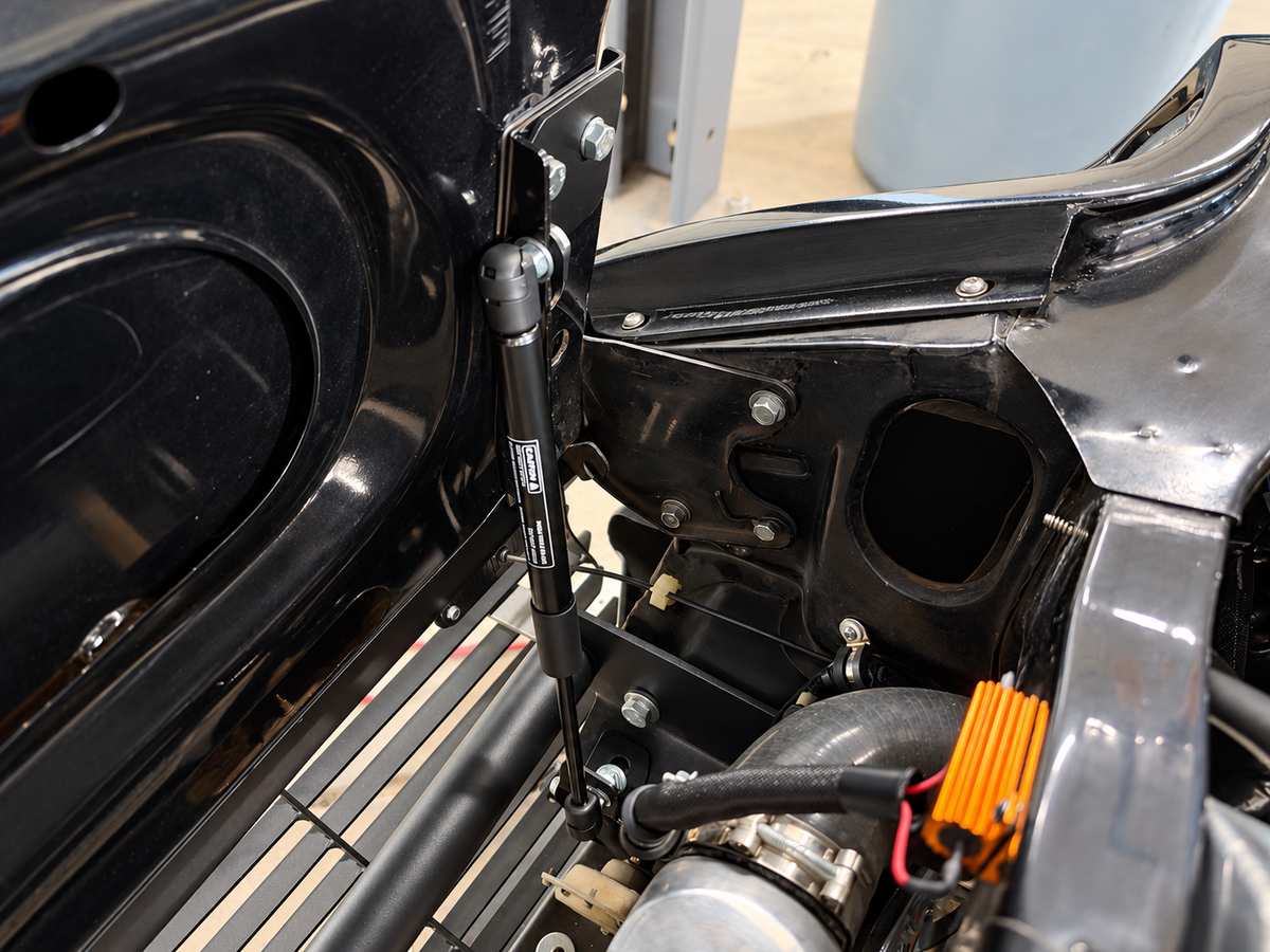 Skillard hood strut kit installed on a Datsun 280ZX, showing the strut and upper and lower mounting points.