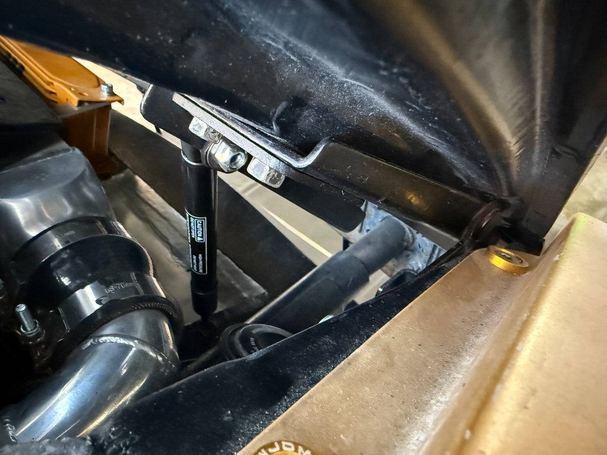 Close view of the Skillard hood strut and upper mounting bracket on a Datsun 280ZX.